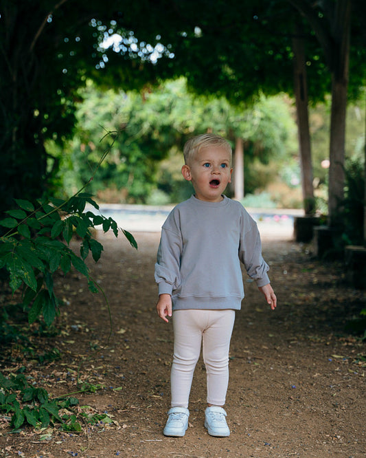 Toddler boy in beige ribbed leggings and soft grey sweatshirt